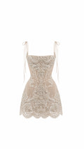 A beige lace corset mini dress with thin tie-shoulder straps, a structured corset bodice, and a flared lace skirt, shown against a plain white background.