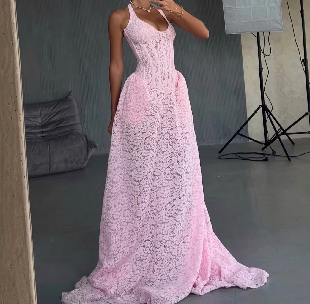 Person wearing a pink lace dress in a studio setting