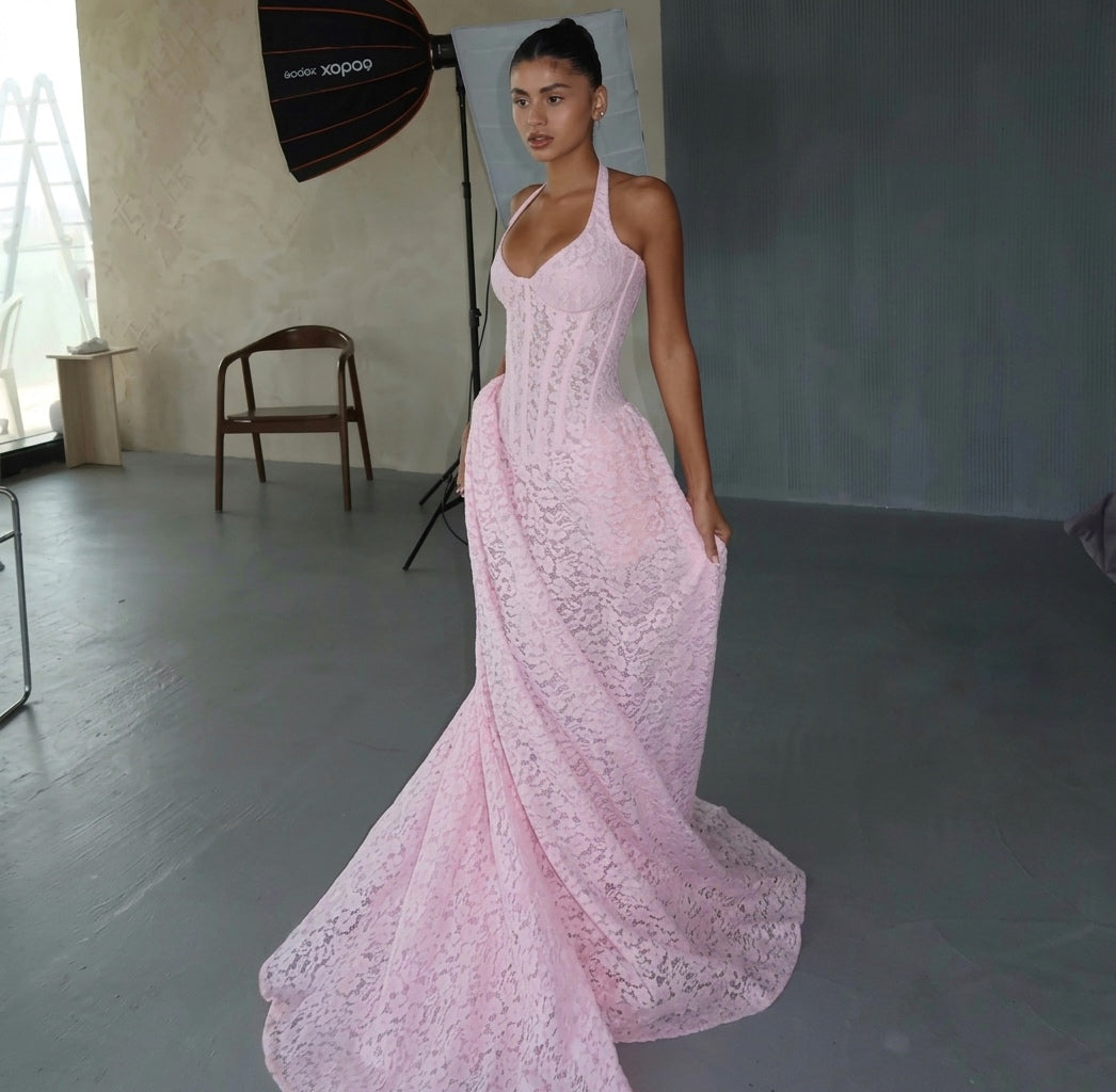 Model wearing a pink lace gown in a studio setting