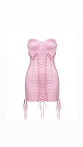 Pink corset dress with lace-up front on a white background