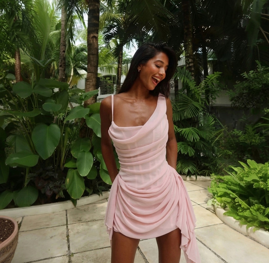 Woman in a pink dress standing in a tropical garden