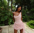 Woman in a pink dress standing in a tropical garden