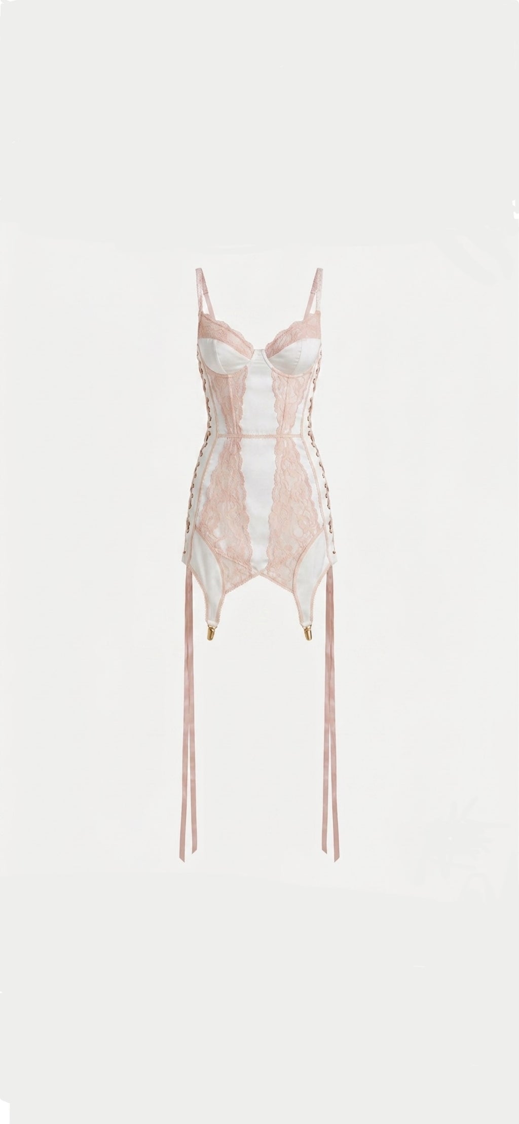 A pale pink and white lace corset bodysuit with thin shoulder straps, side lacing, and long dangling ties, shown against a plain light background.