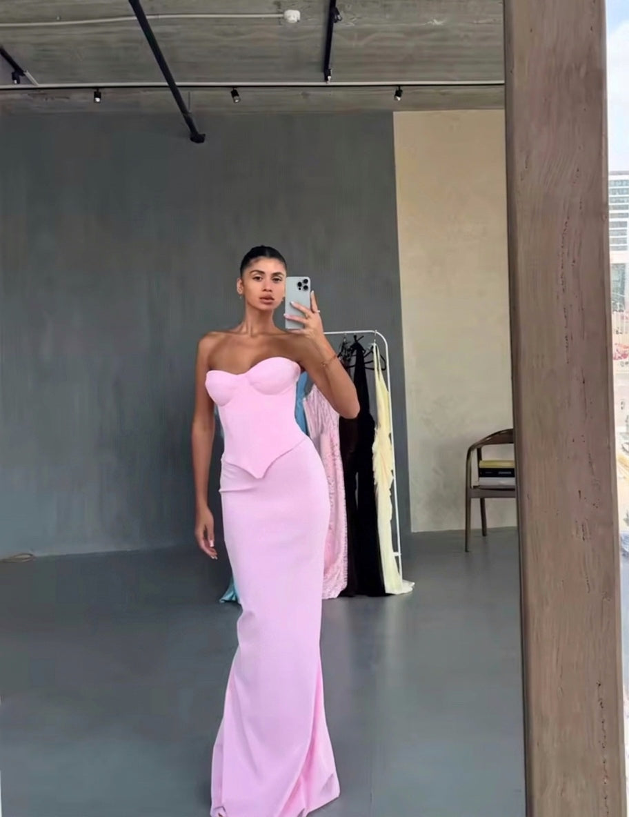 Person wearing a pink strapless gown taking a mirror selfie in an indoor setting.