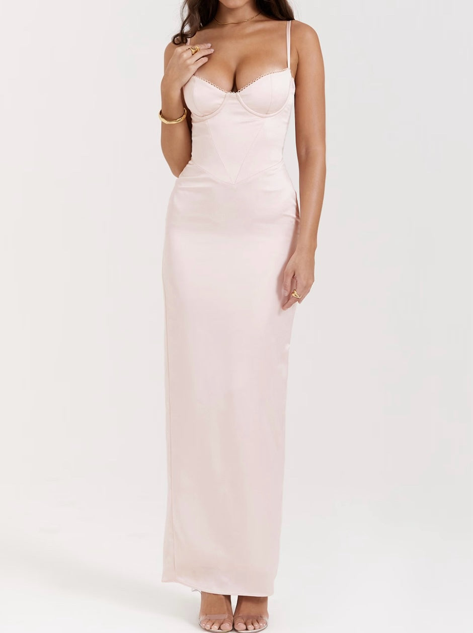 Woman wearing a light pink slip dress on a white background